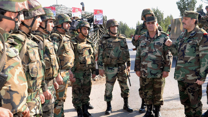 A handout picture released by the Syrian Arab News Agency (SANA) on December 30, 2012 shows Syria's General Fahd Jassem al-Freij (R), Deputy Commander-in-Chief of the Army and the Armed Forces and Minister of Defense, accompanied by senior officers of the General Command, during an inspection of soldiers in Damascus. (AFP Photo/SANA)