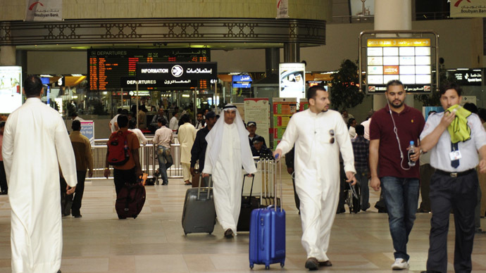 Travellers walk with their luggage at Kuwait International airport (Reuters/Stephanie McGehee)
