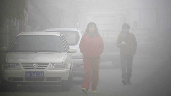 (FILES) Residents walk on a street through heavy smog in Jilin, northeast China's Jilin province on October 22, 2013. (AFP Photo)