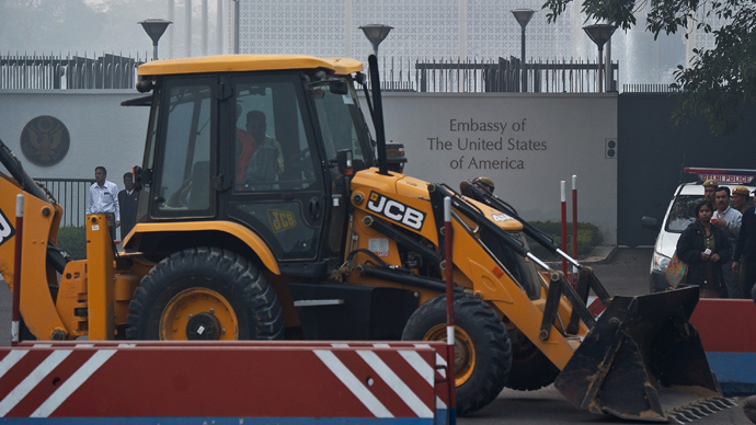 Indian policemen watch as a bulldozer removes a barricade in front of the US Embassy in New Delhi on December 17, 2013 (AFP Photo)