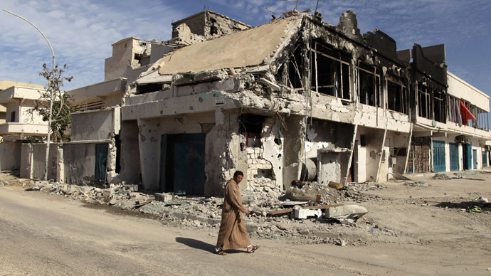 A man walks past a house which was destroyed during fighting between pro and anti-Gaddafi fighters in Sirt November 19, 2011. (Reuters/Mohammed Salem) 