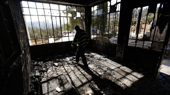 A Palestinian man walks inside his torched house in the West Bank village of Sinjil, near Ramallah November 14, 2013.(Reuters / Mohamad Torokman)