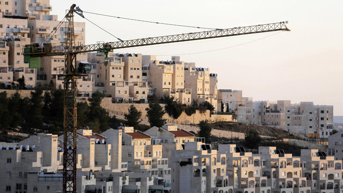 A crane is seen next to homes in a Jewish settlement near Jerusalem known to Israelis as Har Homa and to Palestinians as Jabal Abu Ghneim (Reuters/Ammar Awad)