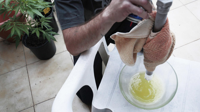 A picture shows a man extracting a liquid containing THC (tetrahydrocannabinol) and CBD (Cannabidiol) (AFP Photo)