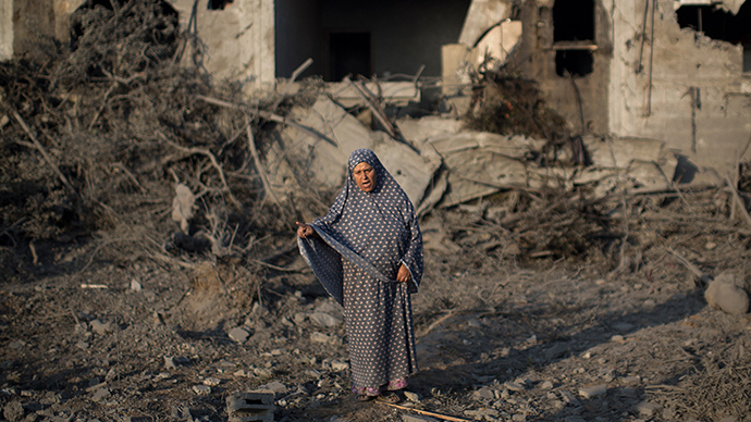 A Palestinian woman gestures as she stands amidst destruction following an Israeli military strike in Gaza City on July 08, 2014 (AFP Photo / Mahmud Hams)