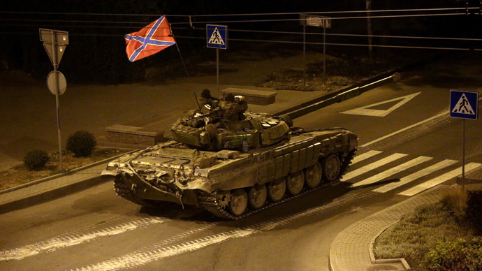 A tank with a flag of Novorossia (union of Donetsk people's republic and Lugansk people's republic) drives in central Donetsk late on August 23, 2014. (AFP Photo / Max Vetrov)