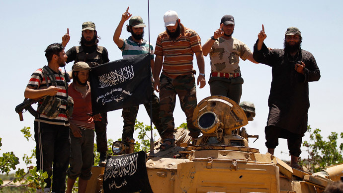 Islamist Syrian rebel group Jabhat al-Nusra members gesture while posing on a tank on Al-Khazan frontline of Khan Sheikhoun, northern Idlib province.( Reuters / Hamid Khatib)