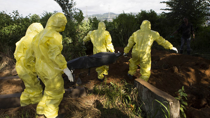 A burial team wearing protective clothing prepare the body of a person suspected to have died of the Ebola virus for interment, in Freetown September 28, 2014. (Reuters/Christopher Black)