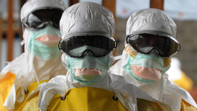 Health care workers, wearing protective suits, leave a high-risk area at the French NGO Medecins Sans Frontieres (Doctors without borders) Elwa hospital in Monrovia. (AFP Photo / Dominique Faget)