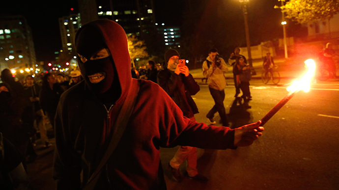 A masked protester holds a flare during a demonstration, following the grand jury decision in the Ferguson, Missouri shooting of Michael Brown, in Oakland, California November 24, 2014 (Reuters / Stephen Lam)