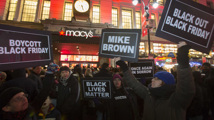 Protesters hold signs aloft outside Macy's before the kick off of Black Friday sales in New York November 27, 2014. (Reuters/Andrew Kelly)