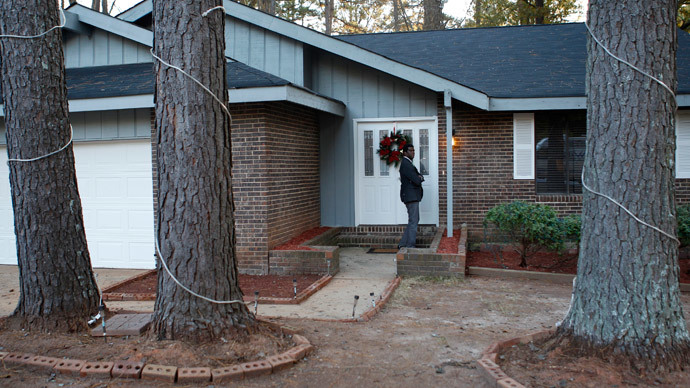 A reporter knocks at the door of the home where a 13-year-old boy who reportedly has been missing for four years, was located by police hidden behind a false wall in a closet in the home in Jonesboro, Georgia November 29, 2014.(Reuters / Tami Chappell)