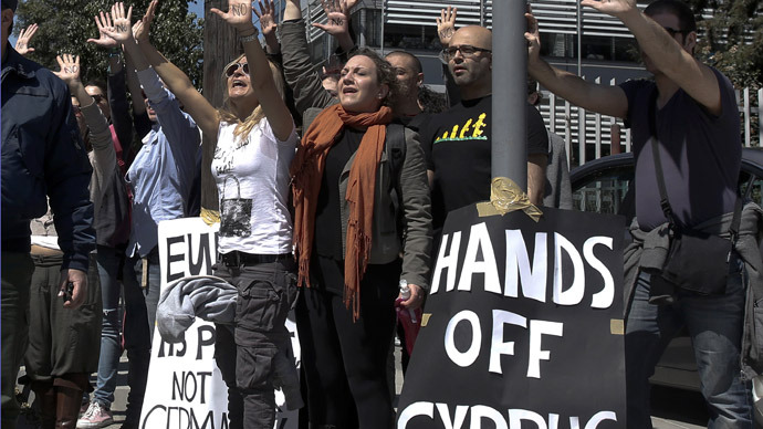 Demonstrators raise their arms in protest as Cypriot President Nicos Anastasiades's convoy drives to the parliament in Nicosia March 18, 2013. (Reuters/Yorgos Karahalis)