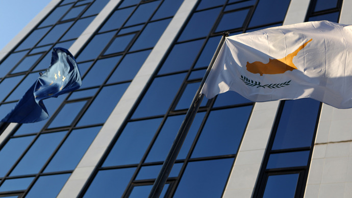 Cypriot and EU flags fly next to a building in the city center of Nicosia (AFP Photo / Patrick Baz)