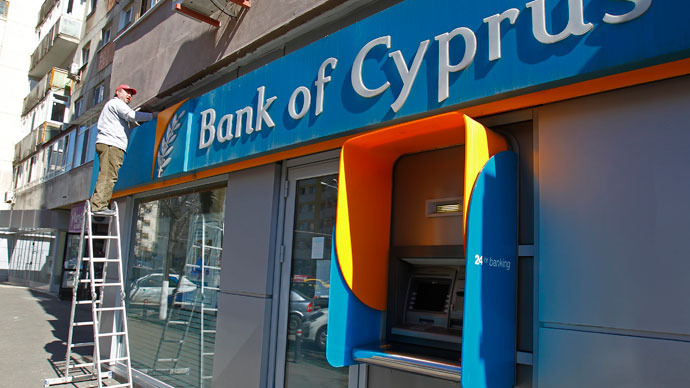 A worker paints a wall above a branch of Bank of Cyprus in Bucharest April 1, 2013.(Reuters / Bogdan Cristel)
