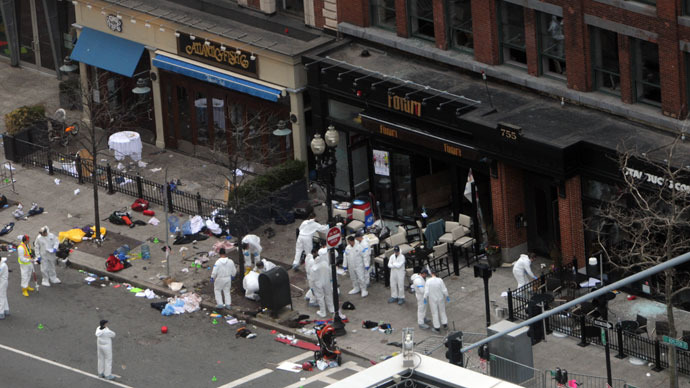 Investigators in white jumpsuits work the crime scene on Boylston Street following yesterday's bomb attack at the Boston Marathon April 16, 2013 in Boston.(AFP Photo / Darren McCollester)