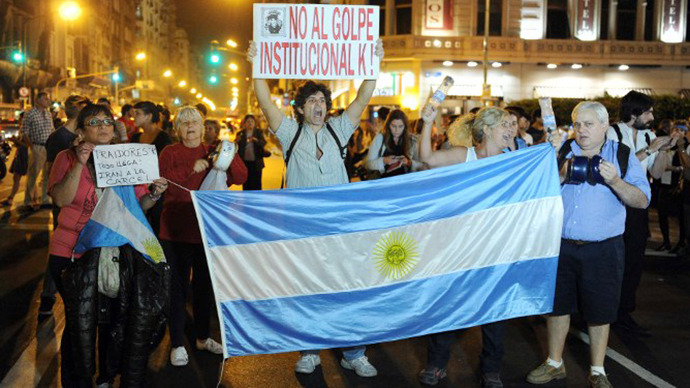 Argentinians protest with a sign reading "No to the institutional K coup!" and a national flag near the Congress building in Buenos Aires on April 25, 2013. (AFP Photo / Alejandro Moritz)