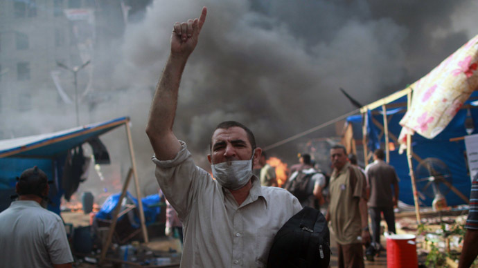 A supporter of the Muslim Brotherhood and Egypt's ousted president Mohamed Morsi gestures during clashes with police in Cairo on August 14, 2013, as security forces backed by bulldozers moved in on two huge pro-Morsi protest camps, launching a long-threatened crackdown that left dozens dead. (AFP Photo/Mossaab El-Shamy)