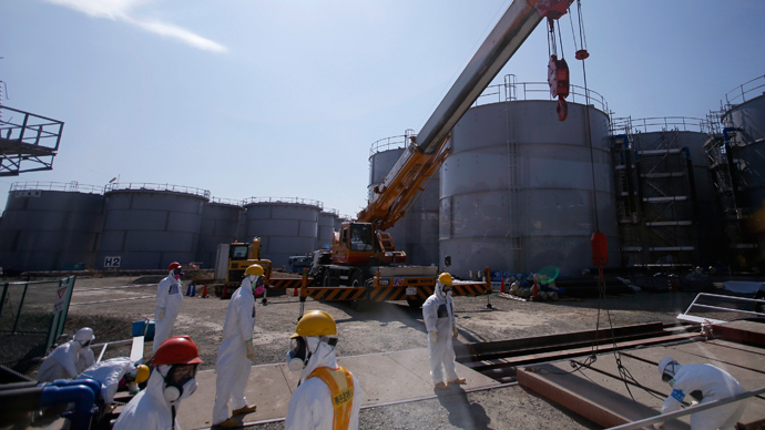 Workers wearing protective suits and masks are seen near tanks of radiation contaminated water at Tokyo Electric Power Company's (TEPCO) tsunami-crippled Fukushima Daiichi nuclear power plant (Reuters / Issei Kato)