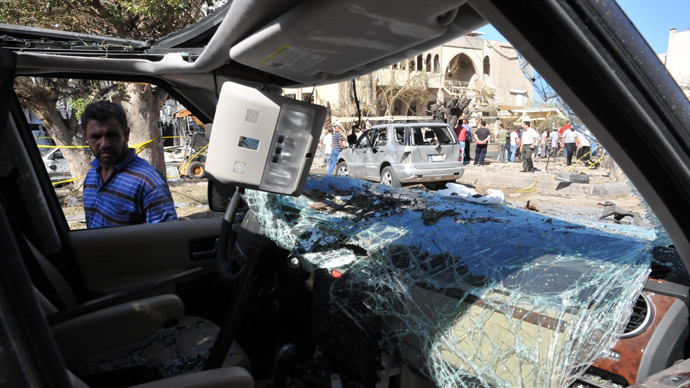 A Lebanese looks at a damaged vehicle on August 24, 2013 on the site of a bombing outside Al-Salam mosque in the northern city of Tripoli (AFP Photo / Ibrahim Chalhoub)
