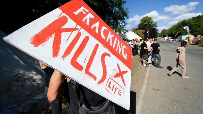 A climate and anti-fracking protester holds a "Fracking kills" placard as he stands outside the test drill site operated by British energy firm Cuadrilla Resources in Balcombe, southern England, on August 20, 2013. (AFP Photo / Leon Neal)