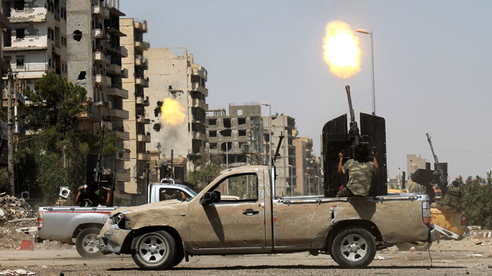 A Syrian rebel fires as a regime fighter jet flies overhead in Syria's eastern town of Deir Ezzor, on August 17, 2013.(AFP Photo / Abo Shuja)