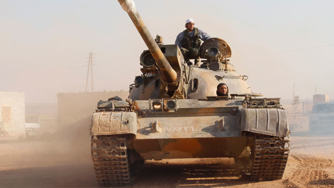 Free Syrian Army fighters drive a military tank that belonged to the forces loyal to Syria's President Bashar Al-Assad after they seized it, in Aleppo's town of Khanasir August 29, 2013.(Reuters / Molhem Barakat)