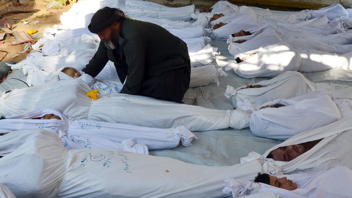 A man holds the body of a dead child among bodies of people activists say were killed by nerve gas in the Ghouta region, in the Duma neighbourhood of Damascus August 21, 2013.(Reuters / Bassam Khabieh)