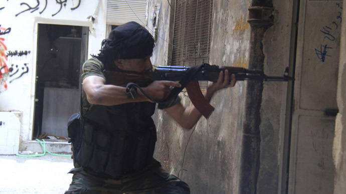 A Syrian fighter aims his weapon as he takes a defensive position in the refugee camp of Yarmouk, near Damascus September 11, 2013. (Reuters/Ward Al-Keswani)