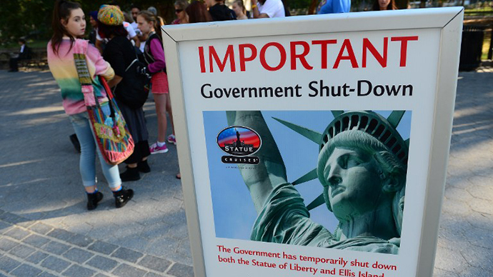 Tourists walk by a sign announcing that the Statue of Liberty is closed due to a US government shutdown in New York, October 1, 2013. (AFP Photo / Emmanuel Dunand)