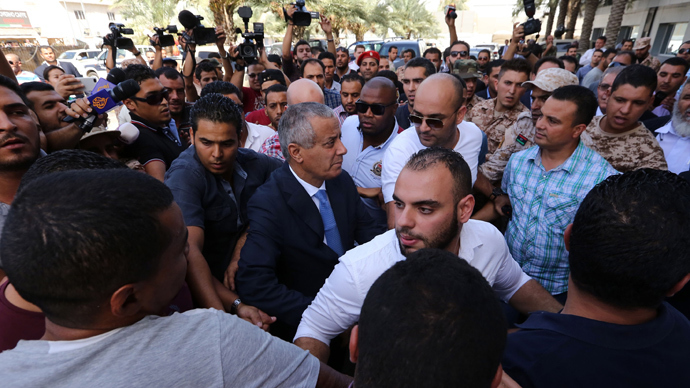 Libyan Prime Minister Ali Zeidan (C) arrives at the government headquarters in Tripoli on October 10, 2013 (AFP Photo / Mahmud Turkia)