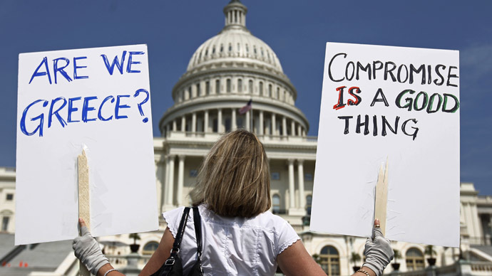 A demonstrator holds placards to protest U.S. debt in front of the Capitol in Washington (Reuters/Kevin Lamarque)