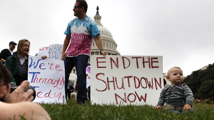 Mason Palmer (R), 10 months old, has his picture taken by his father in front of federal workers demonstrating for an end to the U.S. government shutdown on the west front of the U.S. Capitol in Washington, October 13, 2013. (Reuters)