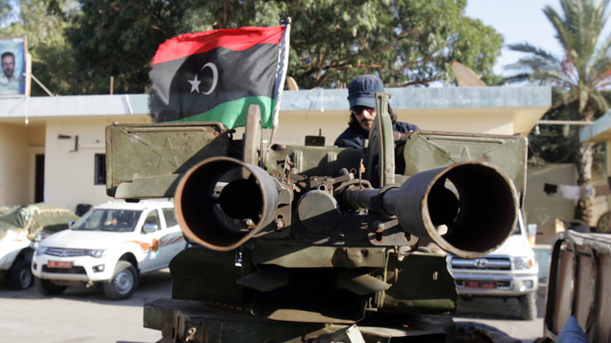 A Libyan citizen soldiers sits on an armed vehicle flying their national flag in the coastal city of Benghazi (AFP Photo)