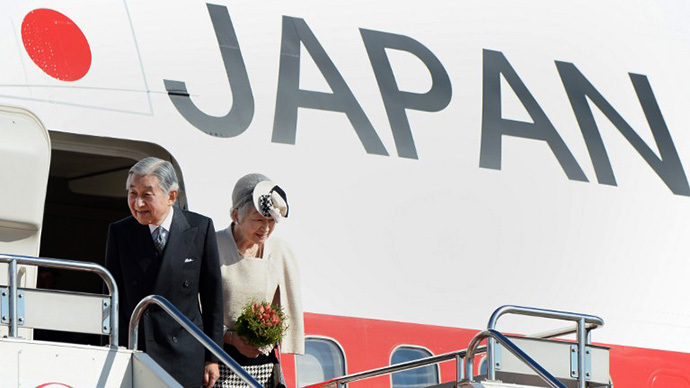 Emperor Akihito (L) and Empress Michiko (R) stand before embarking onto a plane, before they take off for New Delhi, at Haneda Airport in Tokyo on November 30, 2013. (AFP Photo / Toru Yamanaka)