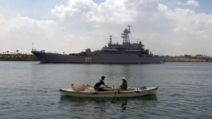 Egyptian fishermen row their boat near the Russian amphibious warfare ship Admiral Nevelsky as it crosses the Suez canal on its way to the Mediterranean sea on May 15, 2013 at Egypt's port town of Ismailia.(AFP Photo / STR)