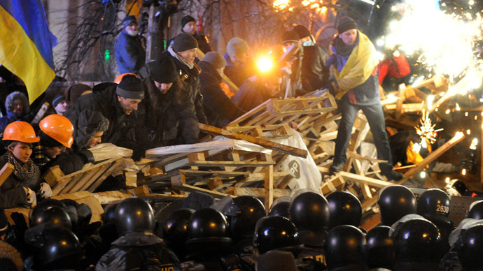 Anti-Yanukovych protesters defend their barricades in front of anti-riot police on Independence Square in Kiev, early on December 11, 2013. (AFP Photo/Victor Drachev)