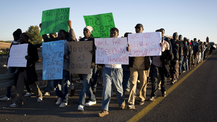 African illegal immigrants take part in a protest march on the highway near Lahav junction in southern Israel on their way to Jerusalem on December 16, 2013 after they fled a detention centre in the south where they were being held. (AFP Photo/Oren Ziv)