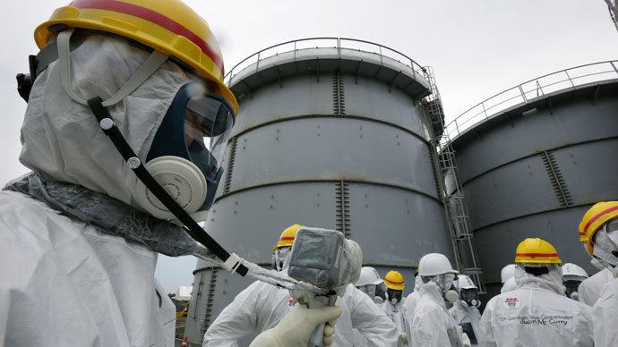 A Tokyo Electric Power Co. (TEPCO) employee wearing a protective suit and mask uses a survey meter near storage tanks for radioactive water in the H4 area where radioactive water leaked from a storage tank in August, at the tsunami-crippled TEPCO's Fukushima Daiichi nuclear power plant in Fukushima prefecture November 7, 2013.(Reuters / Kimimasa Mayama)