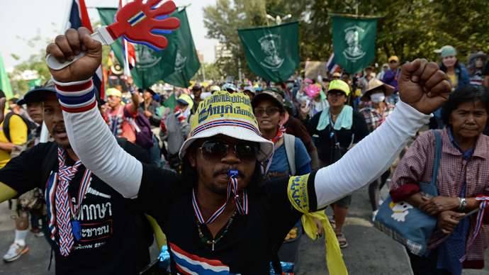 Thai anti-government protesters wave clappers as they march through the streets of Bangkok on January 9, 2014 (AFP Photo / Christophe Archambault)