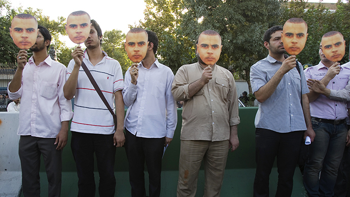 Iranian men hold masks bearing the likeness of 29 year old Afro-Caribbean, Mark Duggan who died from a gunshot wound after an incident involving armed police in London, during a protest in front of the British embassy in central Tehran August 14, 2011. (Reuters / Morteza Nikoubazl)