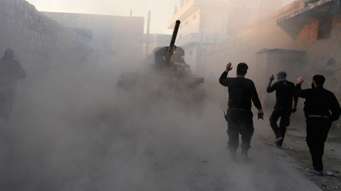 A Free Syrian Army tank drives by Free Syrian Army fighters through a street in Aleppo (Reuters / Molhem Barakat)