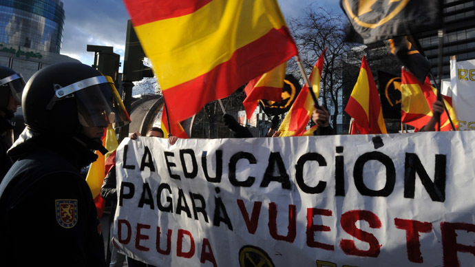 Far-right students wave Spanish flags and hold a banner in front of policemen as they protest against government's austerity measures in Madrid on March 14, 2013. (AFP Photo)
