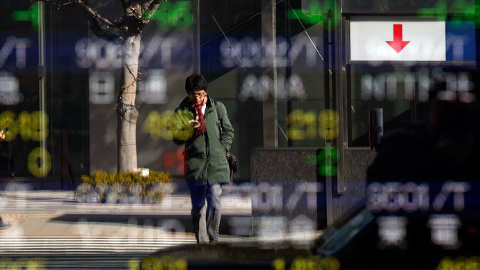 A man is reflected in a stock quotation board outside a brokerage in Tokyo January 28, 2014.(Reuters / Toru Hanai)