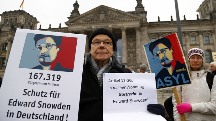 A demonstrator supporting fugitive former U.S. National Security Agency contractor Edward Snowden, holds up a banner outside the Reichstag building, the seat of the German lower house of parliament Bundestag in Berlin November 18, 2013. (Reuters/Tobias Schwarz)