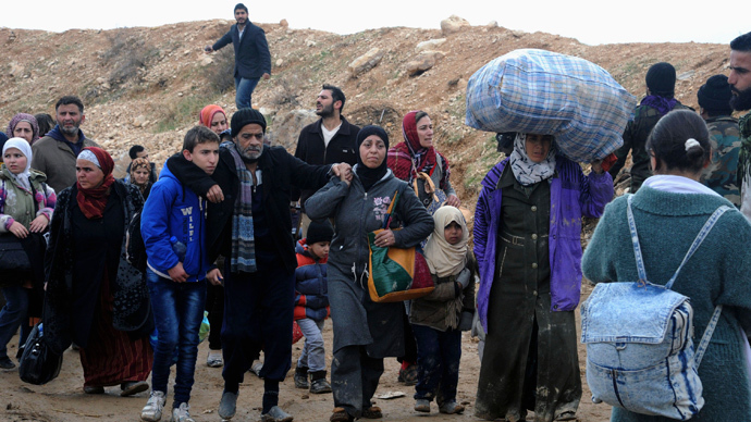 Syrian residents walk near a highway as they flee their homes following clashes between opposition fighters and forces loyal to Syria's President Bashar al-Assad in the Adra area, east of Damascus in this handout photograph released by Syria's national news agency SANA. (Reuters / SANA / Handout via Reuters)