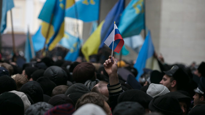 An ethnic Russian Ukrainian holds a Russian flag as Crimean Tatars rally near the Crimean parliament building in Simferopol February 26, 2014. (Reuters / Baz Ratner)