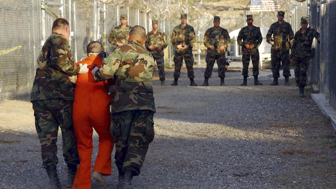 U.S. Army Military Police escort a detainee to his cell during in-processing to the temporary detention facility at Camp X-Ray in Naval Base Guantanamo Bay in this file photograph taken January 11, 2002 and released January 18, 2002. (Reuters)