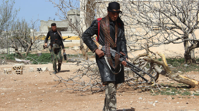 Rebel fighters make their way through a yard in the village of Morek, in the countryside of the Syrian city of Hama (AFP Photo / Ali Nasser)