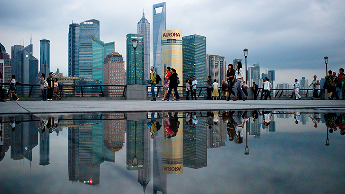 Pedestrians walk past the skyline of the city's financial district in Shanghai (AFP Photo / Philippe Lopez)